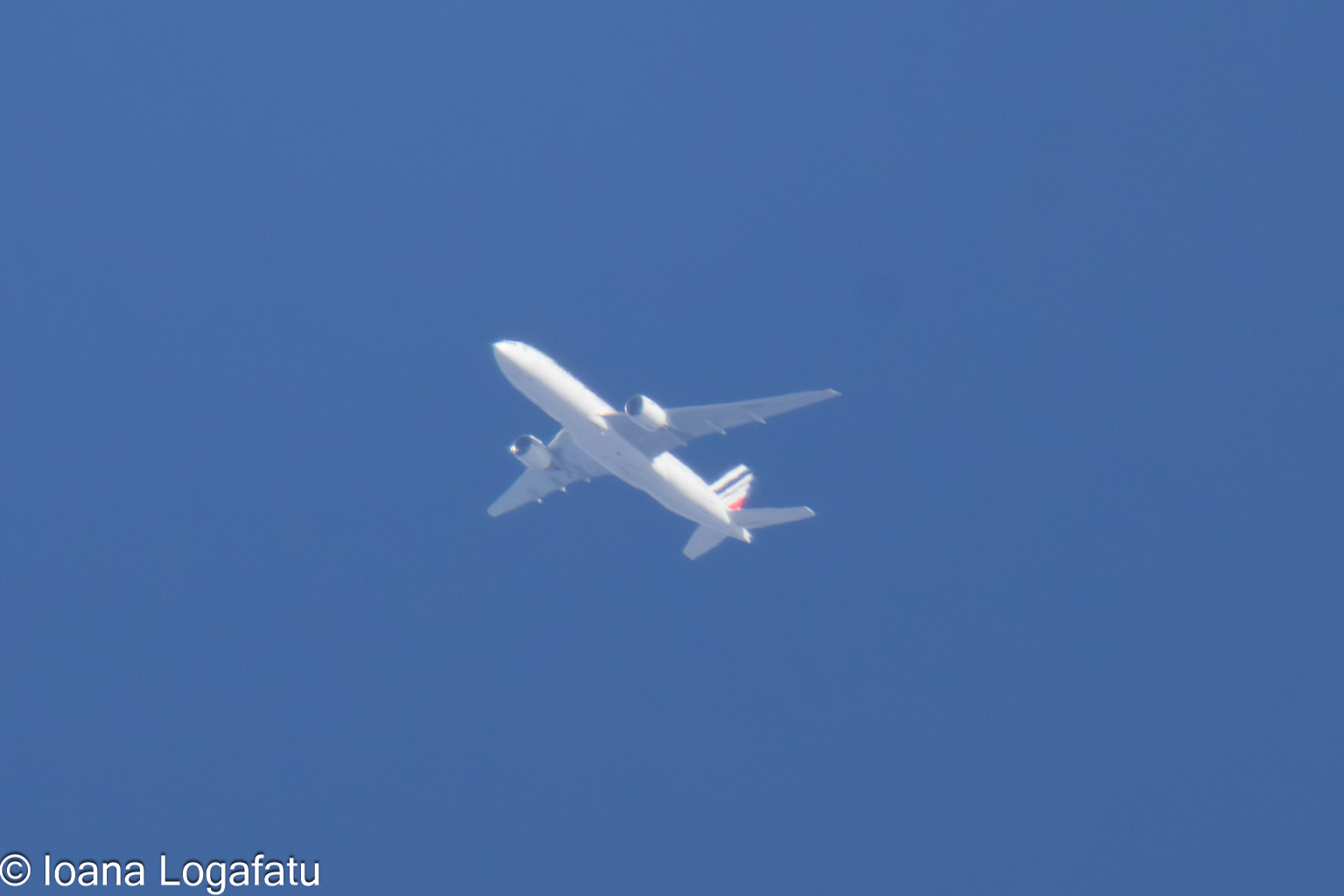 Airplane soaring high above a clear blue sky